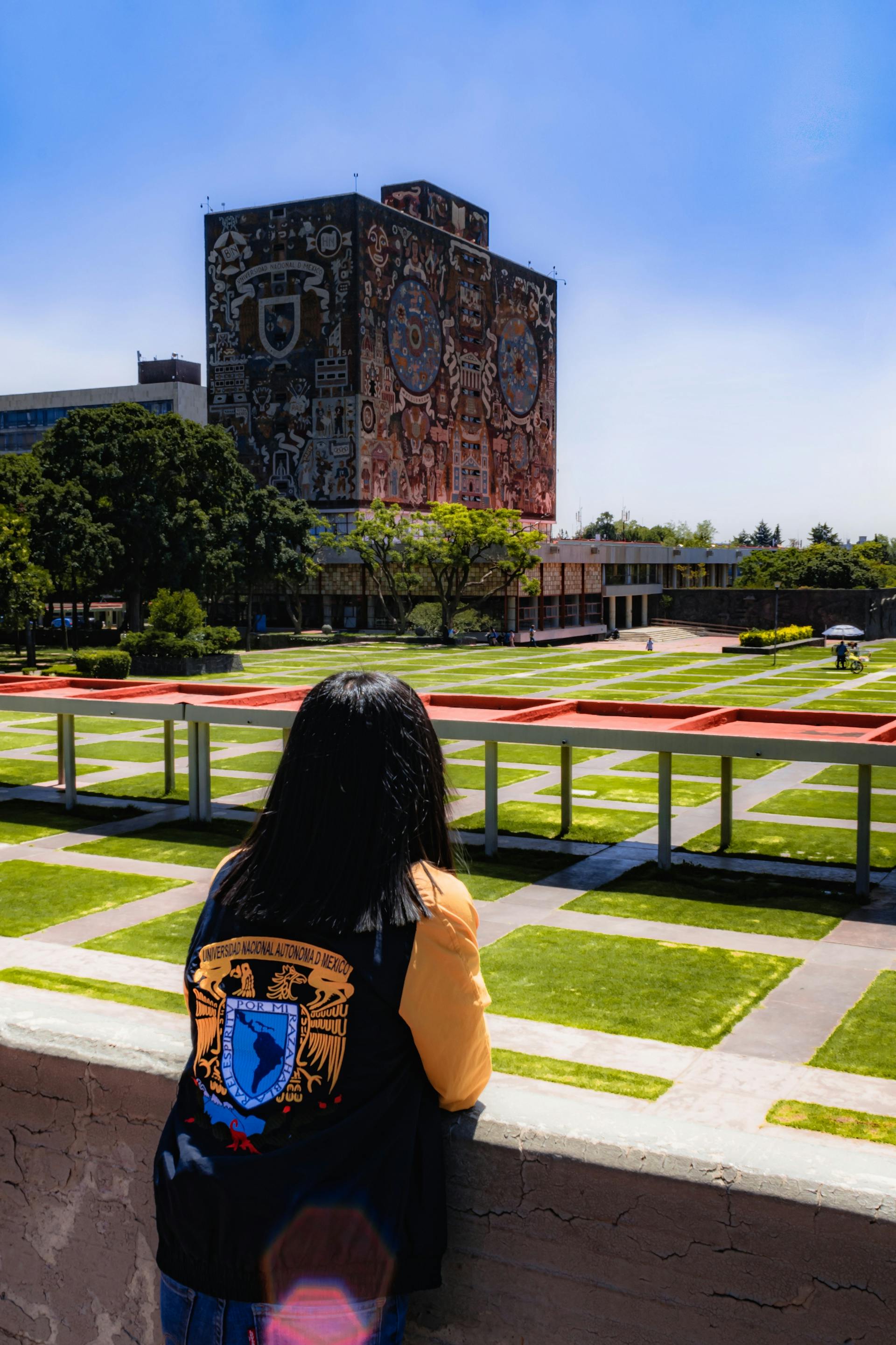 Estudiante frente a la Biblioteca Central de la UNAM en Ciudad Universitaria